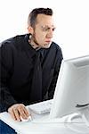 Caucasian mid-adult man with tattoos and piercings using computer.