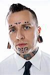 Caucasian mid-adult man with tattoos and piercings wearing necktie.