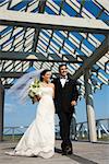 Caucasian mid-adult bride and groom walking together.