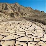 Arrid landscape in Death Valley National Park with dry, cracked ground.