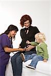 Nurse holding stethoscope on Caucasian pregnant woman's belly.