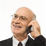 Caucasian middle-aged businessman talking on cellphone smiling against white background.