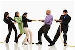 Multi-ethnic businessmen playing tug of war against businesswomen.