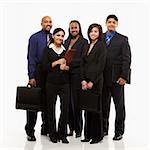 Multi-ethnic business group of men and women standing with briefcases looking at viewer.