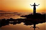 Woman doing yoga at sunset on the seashore