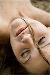 Head shot of pretty Caucasian young adult woman with eyes closed.