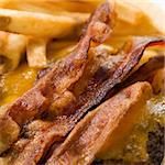 Close up of bacon cheeseburger with french fries.