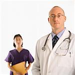 Caucasian mid adult male physician with Asian woman doctor.