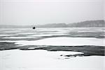 Scenic of frozen lake with ice fishing shack in Green Lake, Minnesota, USA.