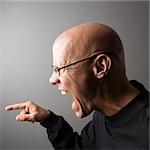 Profile portrait of mid-adult Caucasian male screaming and pointing.