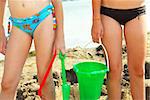 Preteen girls building a sand castle on a beach