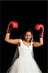 Mid-adult African-American bride wearing boxing gloves.