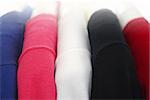 Colorful women's sweaters on a rack on padded hangers