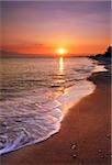 image shows a deserted beach at sunset