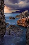 Image shows a rocky seascape during a windy late afternoon