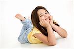 Five year old female child laying on white background smiling wearing casual clothes