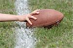 Hand with football reaches over white line