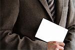 Smartly dressed business man holding a white card (enter your own text).