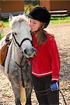 Portrait of a young girl with a white pony