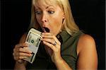 Attractive Woman Excited About her Stack of Money on a Black Background