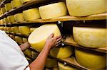 Man inspecting cheese drying in a dairy, Pico Island, Azores, Portugal