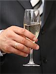 Glass of champagne in a hand of the groom