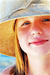 Portrait of a teenage girl wearing a straw hat  on a beach