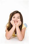 Five year old female child laying on white background smiling wearing casual clothes