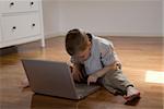 Child sitting on the floor learn how to use a pc