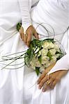 Bride holding her wedding bouquet against her dress