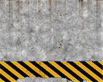 an old yellow and black hazard striped sign on a grungy concrete wall