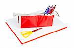 A red pencil case and yellow scissors over a notebook