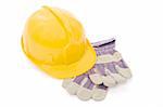 Yellow safety helmet and a pair of industrial protective gloves over white background