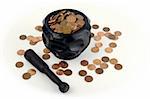 Grinding for Pennies - Wood mortar and pestle containing pennies bills on a white background.