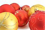 Closeup of red and yellow Christmas ornaments on white background