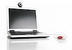 Laptop with a mouse and a webcam over a table with reflection