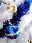 blue and yellow christmas globe in white christmas tree