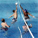 4 men playing water polo in a swimming pool