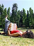 young girl reading book in park