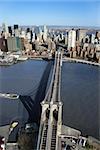 Aerial view of Brooklyn Bridge with East River and Manhattan buildings in New York City.