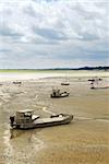 Fishing boats on the ocean floor at low tide in Cancale (Brittany, France)