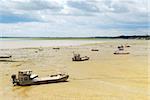 Fishing boats on the ocean floor at low tide in Cancale (Brittany, France)