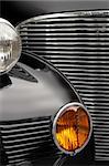 The chrome grill and headlights of an antique classic car.