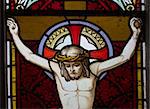 detail of victorian stained glass church window in Fringford depicting Jesus nailed to the cross