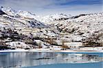 Beautiful blue lake surounded by the mountains covered with snow. Pyrenees, France.