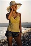 A beutiful young blond woman on a Mediterranean beach lit by golden natural light at sunset
