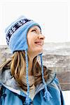 Side view head and shoulder of attractive smiling mid adult Caucasian blond woman wearing blue ski clothing.