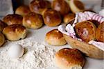 Close up detail of freshly baked hot cross buns and a few ingredients in romantic renaissance lighting and a shallow depth of field.