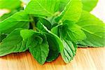 Fresh mint sprigs on wooden cutting board