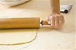 Hand works with rolling pin in kitchen